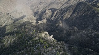 5K aerial stock footage tilt to bird's eye of rugged mountain slope in the San Jacinto Mountains with light snow, California Aerial Stock Footage | AX0010_121E