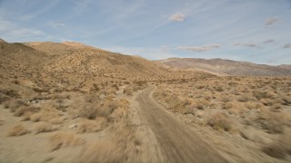 5K aerial stock footage of following desert road through Joshua Tree National Park, California Aerial Stock Footage | AX0011_008E