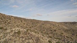 AX0011_023E - 5K aerial stock footage fly low over desert mountain slope, Joshua Tree National Park, California