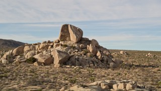 AX0011_032 - 5K aerial stock footage fly over Joshua Trees and rock formation, Joshua Tree National Park, California