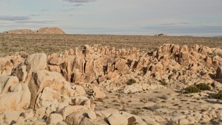 5K aerial stock footage fly over rock formations revealing Joshua Trees, Joshua Tree National Park, California Aerial Stock Footage | AX0011_036