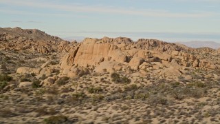 AX0011_038 - 5K aerial stock footage fly by Joshua Trees and rock formations, Joshua Tree National Park, California