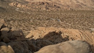 5K aerial stock footage flyby rock formation revealing desert road, Joshua Tree National Park, California Aerial Stock Footage | AX0011_041