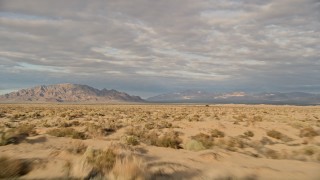 AX0012_002 - 5K aerial stock footage fly low over desert toward mountains, Mojave Desert, California