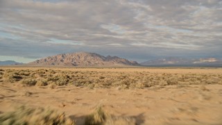 AX0012_004 - 5K aerial stock footage fly over desert vegetation toward mountains, Mojave Desert, California