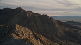 5K aerial stock footage orbiting a desert mountain peak, Mojave Desert, California, sunset Aerial Stock Footage | AX0012_046