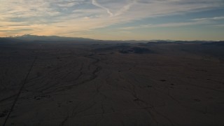 AX0012_055 - 5K aerial stock footage of a flat desert plain at sunset in the Mojave Desert, California