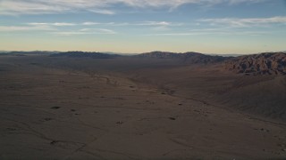 AX0012_056 - 5K aerial stock footage of desert plain and mountains at sunset, Mojave Desert, California