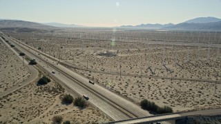 AX0013_025 - 5K aerial stock footage fly over interstate toward windmills, San Gorgonio Pass Wind Farm, California