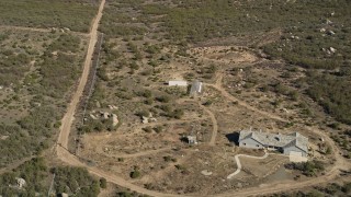 AX0014_021E - 5K aerial stock footage approach and tilt to a rural home, Mountain Center, California