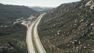 AX0015_003 - 5K aerial stock footage of interstate at the foot of mountains, Temecula, California