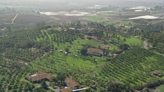 5K aerial stock footage of large homes and farmland atop a hill, Fallbrook, California Aerial Stock Footage | AX0015_035