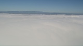 5K aerial stock footage pan across a thick layer of clouds with blue skies overhead, California Aerial Stock Footage | AX0016_005