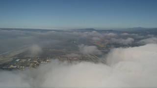 AX0016_015 - 5K aerial stock footage of a view of Camp Pendleton military training base seen while flying over clouds, California