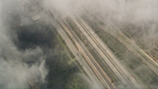 5K aerial stock footage of a bird's eye of light traffic on Interstate 5 through dense clouds, Oceanside, California Aerial Stock Footage | AX0016_035