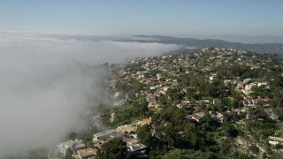 AX0016_058 - 5K aerial stock footage fly over upscale hillside homes and rolling fog, Laguna Niguel, California