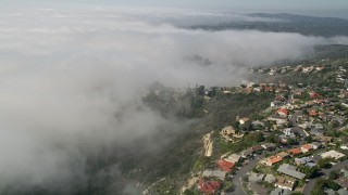 AX0016_059 - 5K aerial stock footage tilt and fly over upscale, hillside homes and a fog bank in Laguna Niguel, California