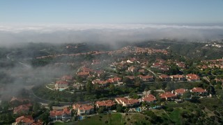 5K aerial stock footage approach and fly over hilltop mansions near a fog bank, Newport Beach, California Aerial Stock Footage | AX0016_070E