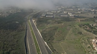 AX0016_077 - 5K aerial stock footage flyby light traffic on Highway 73 near homes and office buildings Irvine, California