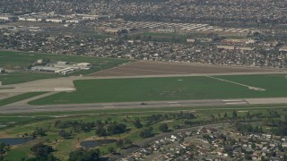 AX0016_095 - 5K aerial stock footage track a military helicopter on the runway at Los Alamitos Army Airfield, California