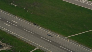 AX0016_097 - 5K aerial stock footage of tracking a helicopter flying low over a runway at Los Alamitos Army Airfield, California