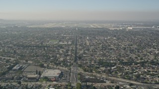 5K aerial stock footage tilt from East Warlow Road through neighborhoods to reveal and approach Long Beach Airport, California Aerial Stock Footage | AX0016_105