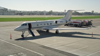 AX0016_115 - 5K aerial stock footage approach and land next to a private jet, Long Beach Airport, California