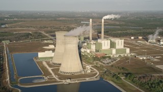 AX0018_031 - 5K aerial stock footage of flying by Stanton Energy Center, a power plant in Orlando at sunrise in Florida