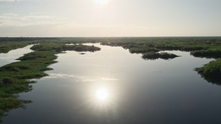 AX0018_045E - 5K aerial stock footage of flying low over St. Johns River near Orlando, Florida at sunrise