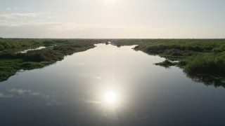 AX0018_049E - 5K aerial stock footage of flying low altitude over St. Johns River near Orlando at sunrise in Florida