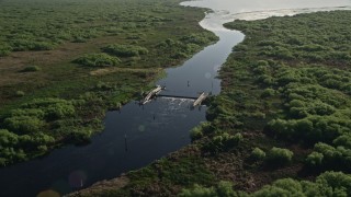 AX0018_060 - 5K aerial stock footage of a levee on St. Johns River near Orlando at sunrise in Florida