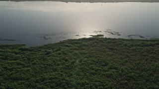 AX0018_062 - 5K aerial stock footage approach the shore of Lake Washington at sunrise in Florida