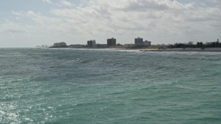 AX0019_036 - 5K aerial stock footage fly low over blue ocean waves near beachfront property in Tequesta, Florida