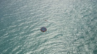 5K aerial stock footage flyby a parasailer in the clear blue ocean by Riviera Beach, Florida Aerial Stock Footage | AX0019_050