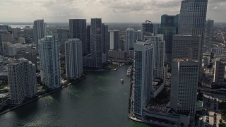 5K aerial stock footage tilt from fishing boats in the bay to reveal skyscrapers and river in Downtown Miami, Florida Aerial Stock Footage | AX0020_026E