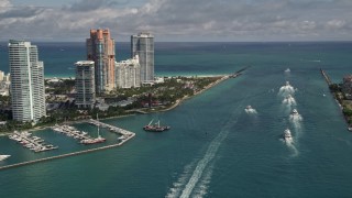 AX0020_040 - 5K aerial stock footage fly over ferries on Government Cut and tilt to reveal South Beach skyscrapers in Florida