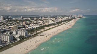 AX0020_044 - 5K aerial stock footage tilt from sunbathers on the beach to a wider view of South Beach, Florida