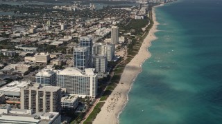 Flyby Beachfront Hotels and Tilt to Sunbathers in Miami Beach  Aerial Stock Footage | AX0020_063