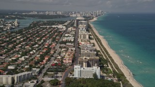 5K aerial stock footage follow Collins Avenue by coastal neighborhoods and beachside condos in Surfside, Florida Aerial Stock Footage | AX0020_066