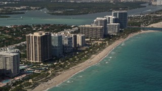 5K aerial stock footage of a row of oceanfront hotels and condominiums by the beach in Bal Harbour, Florida Aerial Stock Footage | AX0020_069