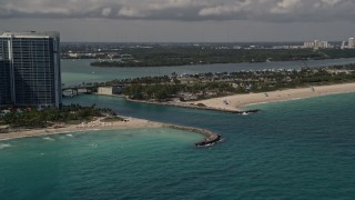 AX0020_070E - 5K aerial stock footage flyby oceanfront buildings to approach an inlet in Bal Harbour, Florida