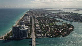 5K aerial stock footage tilt from coastal road to reveal residential neighborhoods in Bal Harbour, Florida Aerial Stock Footage | AX0020_091