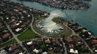 5K aerial stock footage fly over coastal neighborhood to approach boats in small marina in Bal Harbour, Florida Aerial Stock Footage | AX0020_092