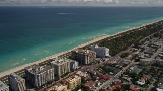 5K aerial stock footage of oceanfront apartments and beach by a park in Surfside, Florida Aerial Stock Footage | AX0020_096