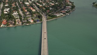 AX0021_011E - 5K aerial stock footage of bird's eye view of light traffic on Broad Causeway, tilt to reveal Bay Harbor Islands neighborhoods, Florida