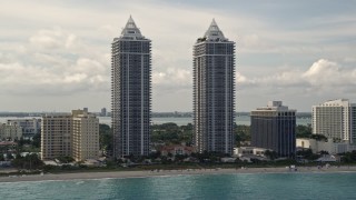 5K aerial stock footage tilt from blue ocean to reveal and approach the Blue and Green Diamonds skyscrapers in Miami Beach, Florida Aerial Stock Footage | AX0021_046