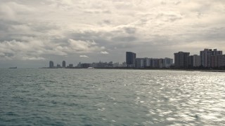 5K aerial stock footage of low altitude view of oceanfront condos along the coast in Miami Beach, Florida Aerial Stock Footage | AX0021_048E