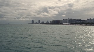 5K aerial stock footage tilt from ocean to reveal oceanfront hotels and condos in Miami Beach, Florida Aerial Stock Footage | AX0021_050E