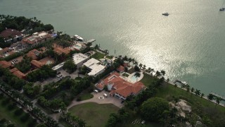 AX0021_075 - 5K aerial stock footage approach waterfront mansion and tilt to a bird's eye view of Star Island, Florida