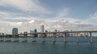 5K aerial stock footage of Rickenbacker Causeway with light traffic, reveal Downtown Miami skyline, Florida Aerial Stock Footage | AX0021_112E